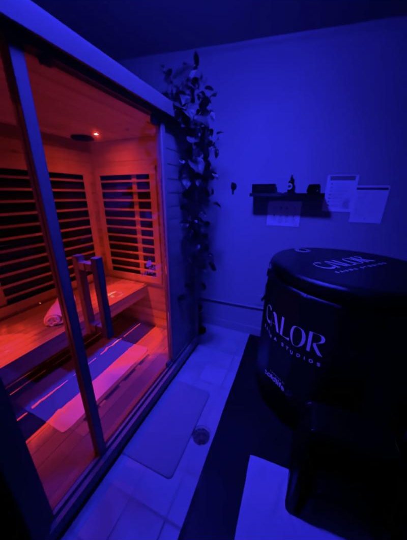 The cold plunge suite: an infrared sauna beside a Calor cold plunge tub under blue light